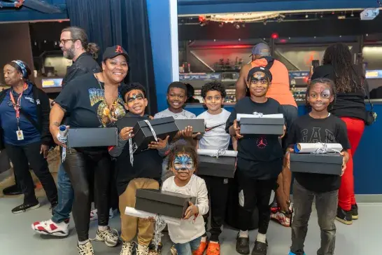 Kids with face paint posing with the prize they won during the event