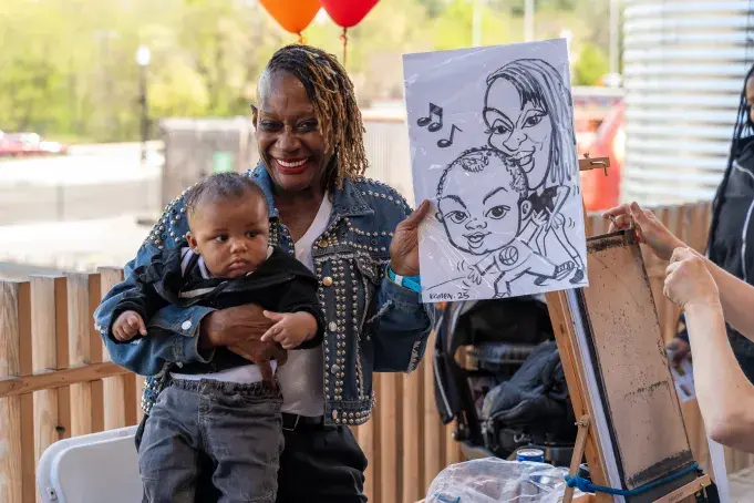 A mother and child posing with their caricature